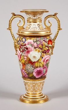 a gold vase with flowers painted on the front and sides, sitting against a white background