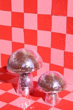 two shiny mushrooms on a checkered red and white floor with pink squares in the background