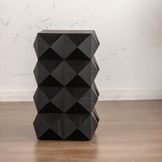 a black sculpture sitting on top of a wooden floor