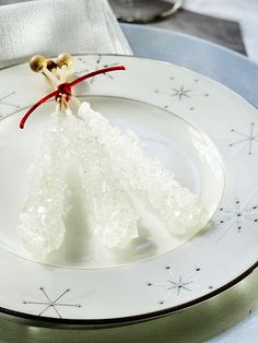 a white plate topped with an ornament on top of a blue table cloth