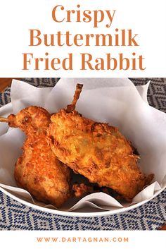 two fried chicken wings in a white bowl on a blue and white tableclothed placemat