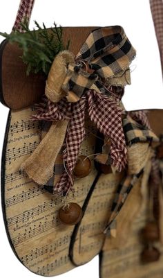 a wooden sign with musical notes and bells hanging from it's sides, decorated with burlap