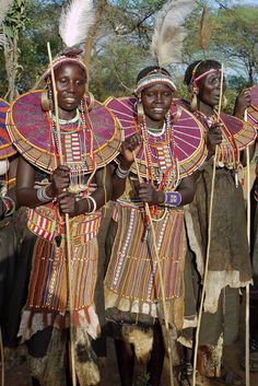 some people are dressed up and posing for the camera with their headgear on