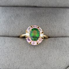 This truly one of a kind estate green tourmaline ring has a stark color contrast. The tourmaline's forest green color presents a stark contrast to the pink topaz accent stones. The center stone is an oval-cut chrome tourmaline that weighs 1.68 carats and is accented by 1.2 carats of oval-cut pink topaz and 0.22 carats of round diamonds. In total the ring weighs 5.3 grams and is made of 18K yellow gold. The pink topaz accent stones range from a pale pink to an almost medium pink.  The green tourm Chrome Tourmaline, Green Tourmaline Ring, Green Chrome, Pink Tourmaline Ring, Forest Green Color, Pink Topaz, Tourmaline Ring, Color Contrast, Green Tourmaline