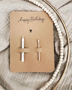 a pair of white candles sitting on top of a piece of paper next to a string