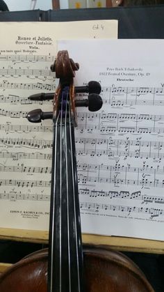 a violin sitting on top of sheet music