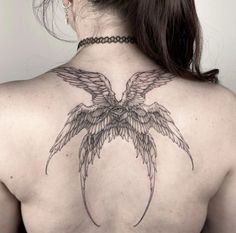 the back of a woman's neck with wings on it