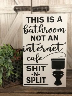 this is a bathroom not an internet cafe sign on a shelf next to a potted plant