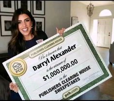 a woman holding up a large check for $ 1, 000