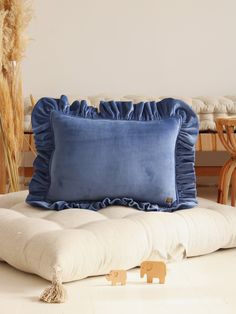 a blue pillow sitting on top of a white couch