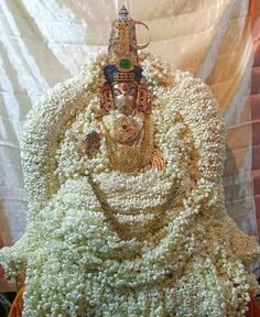 the statue is covered in flowers and beads