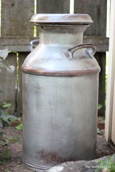 an old metal milk can sitting on the ground