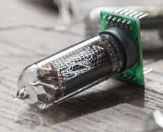 a close up of a small electronic device on a wooden table with wires and other electronics