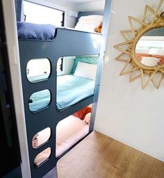 bunk beds in a small room with mirrors on the wall and wood flooring around them