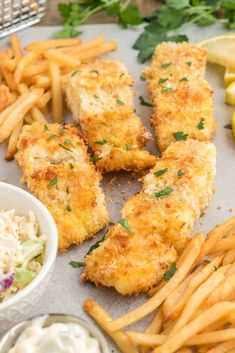 fried fish and french fries with coleslaw, lemon wedges on the side