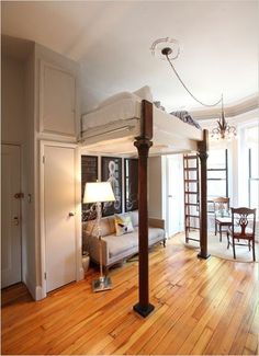 a loft bed in the middle of a living room with hardwood floors and white walls