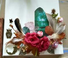 a box with feathers, flowers and other items on it