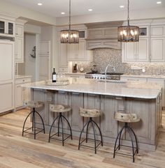 a large kitchen with an island and bar stools