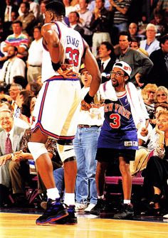 two basketball players standing next to each other in front of an audience at a game