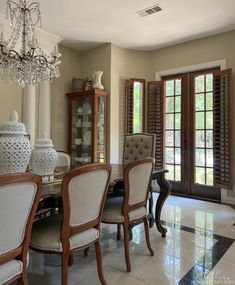 a dining room table and chairs with chandelier in the middle of the room