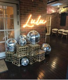 some shiny glass balls are on display in front of a brick wall with the word luftu