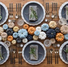 the table is set with pumpkins, silverware and other decorative items on it