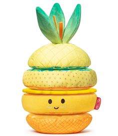 a stack of pillows with a pineapple on top and a smiley face in the middle