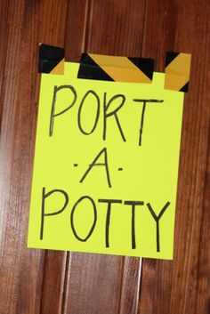 a yellow sign that says port a potty hanging on a door with black and yellow tape