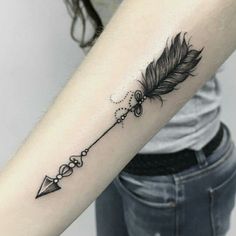 a woman's arm with a feather and an arrow tattoo on the left forearm