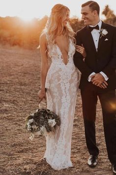 a bride and groom standing in the desert at sunset with sun shining down on them