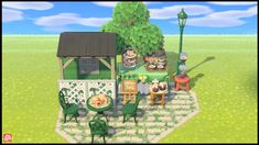 a small green house in the middle of a grassy area with tables and chairs around it