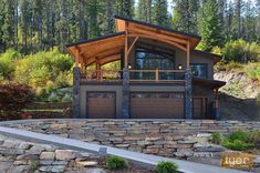 a large house sitting on top of a lush green hillside next to a forest filled with trees