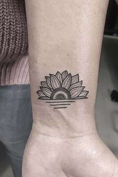 a small sunflower tattoo on the wrist