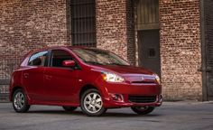 a red car parked in front of a brick building