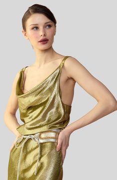 Metallic olive gold silk lamé cowl neck top.Complete the look: Shimmering Siren Skirt Metallic olive gold silk lamé cowl neck top. Cowl neckline Low back with V-straps Made in Italy Italian metallic lamé fabric Fabric content: 85% silk, 15% metallic lurex Care instructions: dry clean only Fit: model is 5'9 and wears a size S. Size S measurements: Length from shoulder: 20" Complete the look: Shimmering Siren Skirt Gold Silk Evening Top, Gold Silk Top For Evening, Gold Silk Top For Night Out, Siren Top, Lamé Fabric, Lame Fabric, Denim Capri, Metallic Rose Gold, Cowl Neck Top