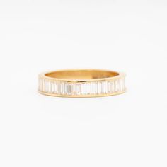 a yellow gold band with baguets on the side, set in white diamonds