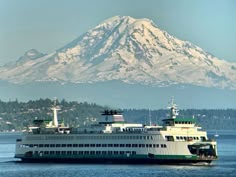 a large boat in the water with a mountain in the background