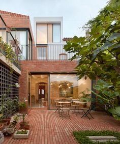 a brick patio with potted plants and chairs