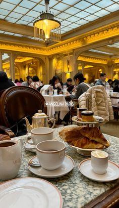 a table topped with lots of cups and saucers filled with food next to each other