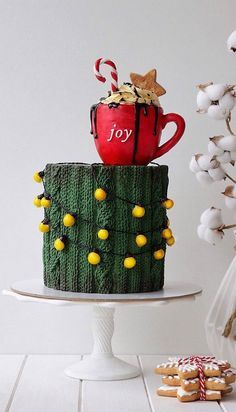 there is a cake that has been decorated like a christmas tree and coffee mug on top