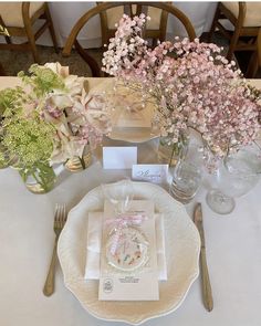 the table is set with flowers and place settings