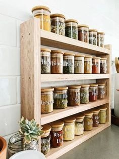 a wooden spice rack filled with lots of different types of spices on top of a counter