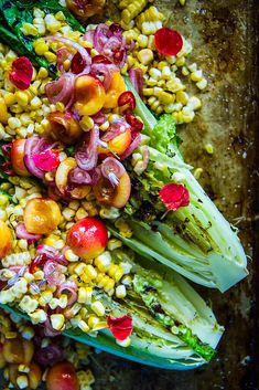 an overhead view of corn and vegetables on a baking sheet