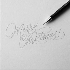 the word merry christmas written in cursive writing on white paper with a black pen