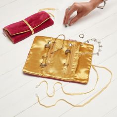 a gold purse sitting on top of a white floor next to a handbag and chain