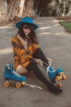 a young woman sitting on the ground with her skateboard in front of her feet