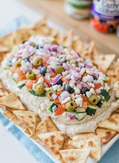 a white plate topped with nachos and lots of toppings on top of it