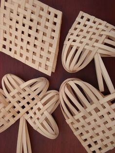 four pieces of wood are arranged in the shape of heart shaped baskets on a table