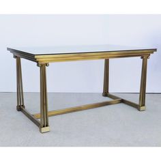 a glass and brass coffee table with two legs