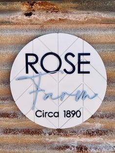 the rose farm sign is painted white and blue